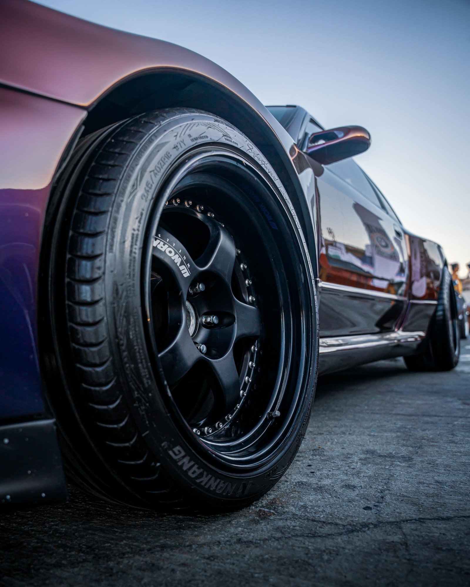 Detailed shot of a custom sports car wheel at sunset in İzmir, Türkiye, showcasing car culture.
